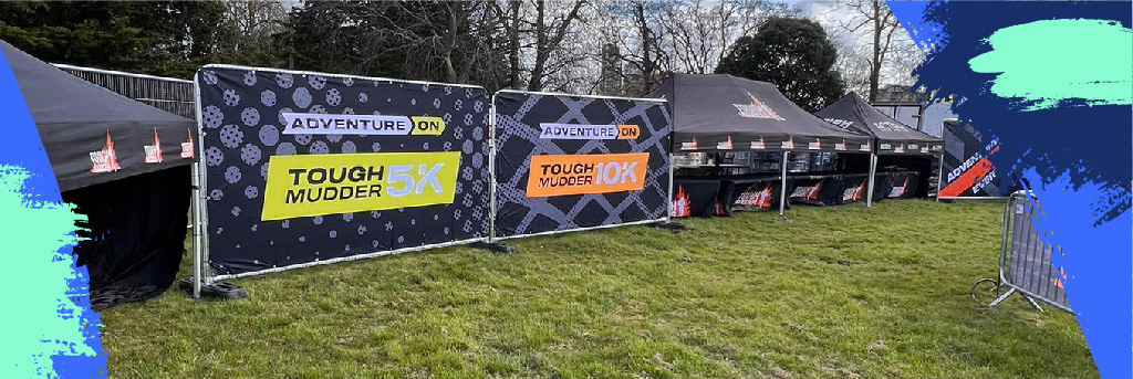 Branded fencing and barriers at an outdoor Tough Mudder event